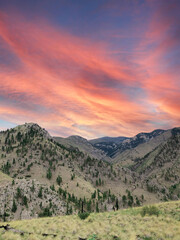 Wall Mural - View of mountains with green trees under the red and blue sky