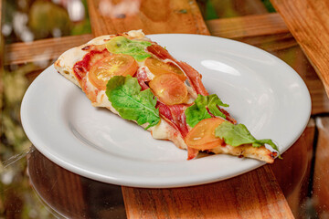 Poster - Closeup of a slice of pizza with serrano ham, tomato and basil