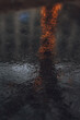 Vertical shot of wet asphalt texture with the reflection of evening lights after the rain