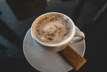 Poster - Cup of coffee with a saucer and a cookie on a table