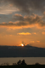 Wall Mural - Vertical shot of a sunset on the horizon with a cloudy sky