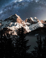 Wall Mural - Vertical shot of snowy mountains under a mesmerizing starry sky
