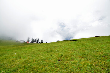 Poster - Scenic view of smooth and wide green meadows under the cloudy sky