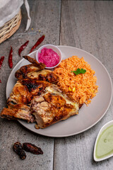 Poster - Vertical shot of shot of grilled chicken peaces with rice porridge and red cabbage with sauce pot