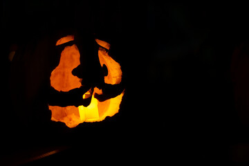 Sticker - Closeup of a pumpkin with a candle on a dark background