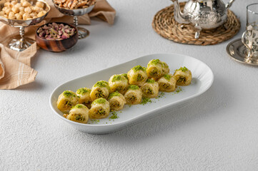 Wall Mural - White plate of fresh tasty and sweet Baklava on the table with nuts