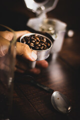 Wall Mural - Vertical shot of a man's hand holding coffee beans