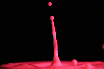 Sticker - Closeup of a pink juice drop splash on a black background