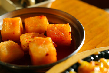 Diced radish kimchi is provided on stainless steel plate.