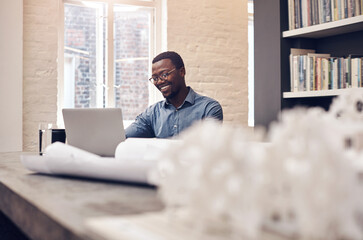 Poster - Isnt it great when everything starts to come together. Cropped shot of a handsome young male architect smiling while working on a laptop in a modern office.