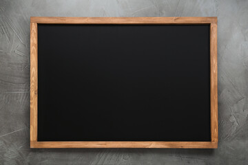 clean black chalkboard with wooden frame on grey background