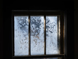 Fototapeta Na ścianę - Old fashion window covered in frost with morning light shining thru the glass, dark contrast inside, shadows and light.