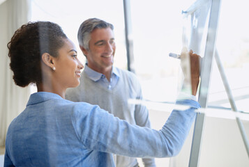 They value each others expertise. Shot of two coworkers discussing ideas while standing by a whiteboard.