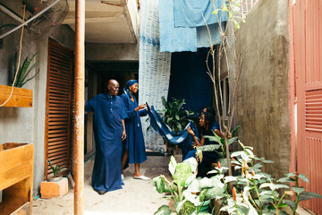 Canvas Print - Portrait of a group of african textile entrepreneurs talking together and inspecting their organic products