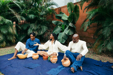 Wall Mural - African female teacher teaching her team of entrepreneurs how to eco dye their organic fabrics