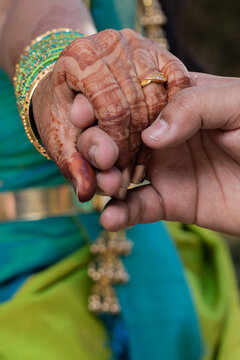Closeup shot of the hands of Indian bride and groom in romantic moment