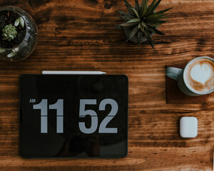 Poster - Top view of mug of Nescafe with tablet and blue tooth earphones on a woden table