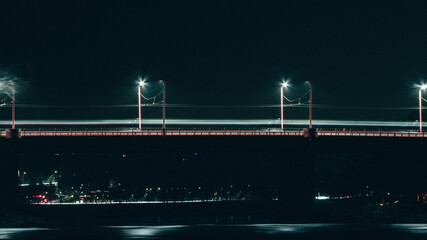Wall Mural - vertical shot of a bridge with street lamps against night sky