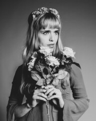 Poster - Vertical greyscale portrait of an attractive woman holding a rose bouquet