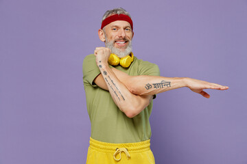 Wall Mural - Happy elderly gray-haired bearded man 40s years old in headband khaki t-shirt stratching isolated on plain pastel light purple background studio portrait. Workout sport motivation lifestyle concept.