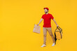 © ViDi Studio - Full length delivery guy employee man in red cap T-shirt uniform work as dealer courier hold brown blank craft paper takeaway bag mock up thermal food bag backpack isolated on plain yellow background.
