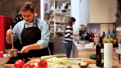 Caucasian couple cooking in the kitchen at home. Mature age, middle age, mid adult white man in 50s.