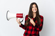 © luismolinero - Teenager Brazilian girl isolated on white background holding a megaphone and pointing side