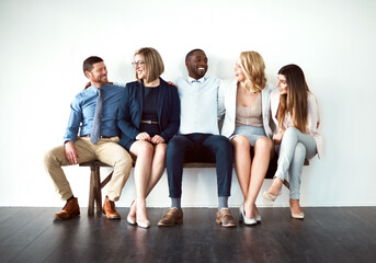 Poster - So what are you guys doing today. Shot of a group of work colleagues seated next to each other against a white background.