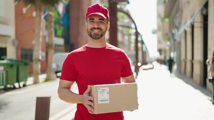 Canvas Print - Young hispanic man deliveryman holding package at street