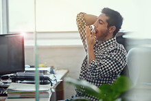 Works Really Taking Its Toll. Cropped Shot Of A Businessman Yawning While Working At His Desk.