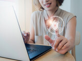 Fototapeta  - Cyber security, personal data protection, and business privacy concept. Shield and lock icon in the air while woman scanned by her finger for access identification while using laptop computer.