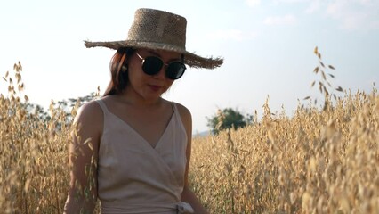 Wall Mural - Slow motion young woman walking at barley wheat field on sunny day.