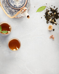 Canvas Print - Asian teapot with herbal tea on light background.