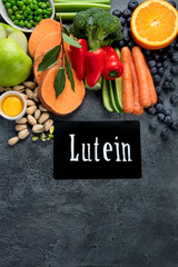 Wall Mural - Foods high in lutein on dark background.