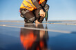© dusanpetkovic1 - Cropped picture of a worker installing solar panels on the roof.