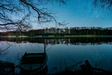 Fototapeta  - Łódka nad jeziorem w trakcie pogodnej nocy.  Łódź lub statek i gwiazdy. Łowienie ryb nocą.