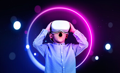 Wall Mural - Child in formal suit is wearing vr helmet. Circle hologram