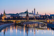 Illuminated Moscow Kremlin and Bolshoy Kamenny Bridge in the night. View from the Patriarshy pedestrian Bridge in Russia. Evening urban landscape in the blue hour