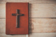 Christian cross with the holy bible on wooden , Vintage Christian Cross, Concept of hope , christianity , faith, religion and church online.
