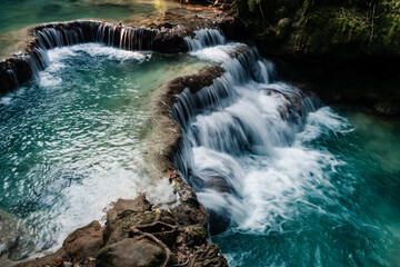 Wall Mural - amazing turquoise water of kuang si waterfall in tropical rain forest. laos