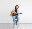 © Akarawut - Asian artist singing song and playing acoustic guitar on white background for live acoustic concert and music related concept with copy space