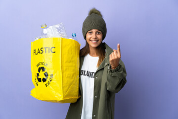 Poster - Young woman holding a bag full of plastic doing coming gesture