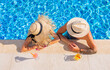 © Kaspars Grinvalds - Couple enjoying drinks by the pool, overhead view