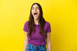 Young caucasian woman isolated on yellow background shouting to the front with mouth wide open