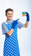 © Ольга Новицкая - a man in a blue apron, rubber gloves, an orange t-shirt, jeans and white sneakers holds sponges for washing dishes. isolated white background