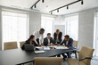 © fizkes - Concentrated successful happy diverse colleagues analyzing financial paper documents at briefing meeting, developing corporate growth strategy or discussing marketing research results in modern office