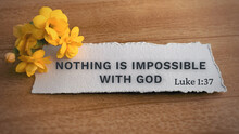 Top View Of Bible Verse Nothing Is Impossible With God. Yellow Flower And Wooden Background.