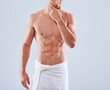 Abs-alicious. Cropped studio shot of a handsome bare chested young man with his waist wrapped in a towel.