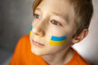 © Roman - a boy with a painted flag of Ukraine raised his head to the top