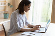 © fizkes - Attractive young serious businesswoman sit at table types texting on laptop keyboard, makes research, prepare report working from homeoffice in quarantine. Modern tech, distance job, workflow concept